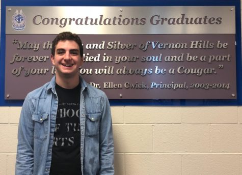 Sam Lemme stands in front of the VHHS graduate sign.