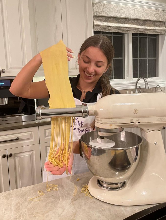Paige+watches+her+pasta+dough+go+through+the+Kitchen+Aid+pasta+cutter.