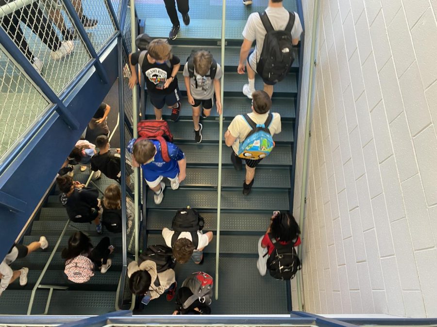 Students walk up and down the stairs during a passing period.