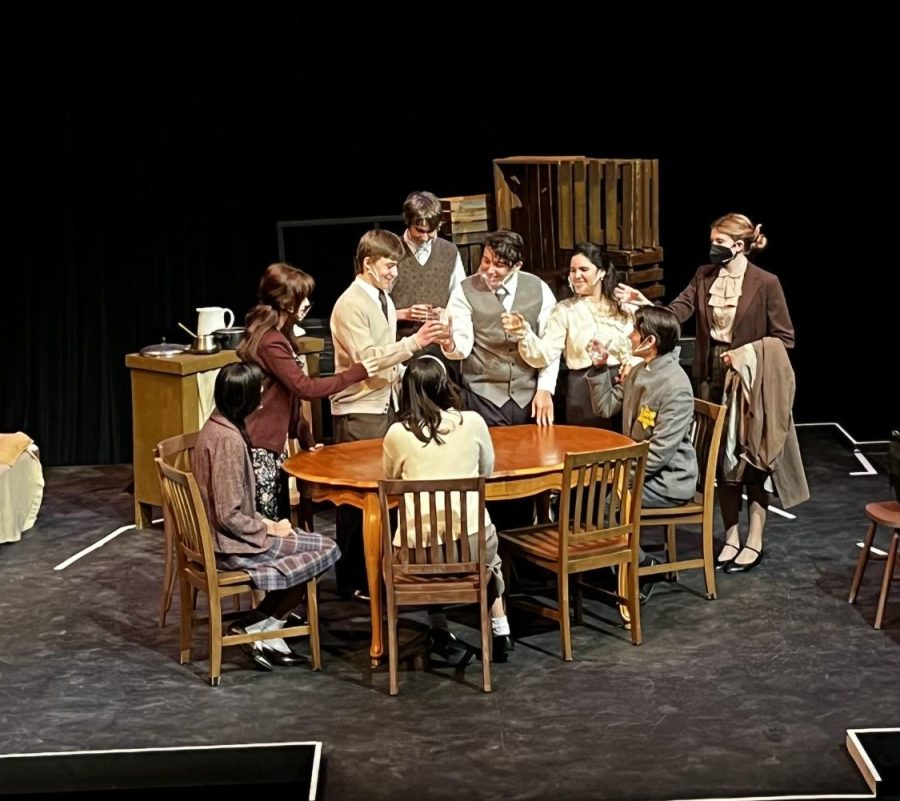 The cast of The Diary of Anne Frank toasts to Mr. Dussel arriving at the annex.