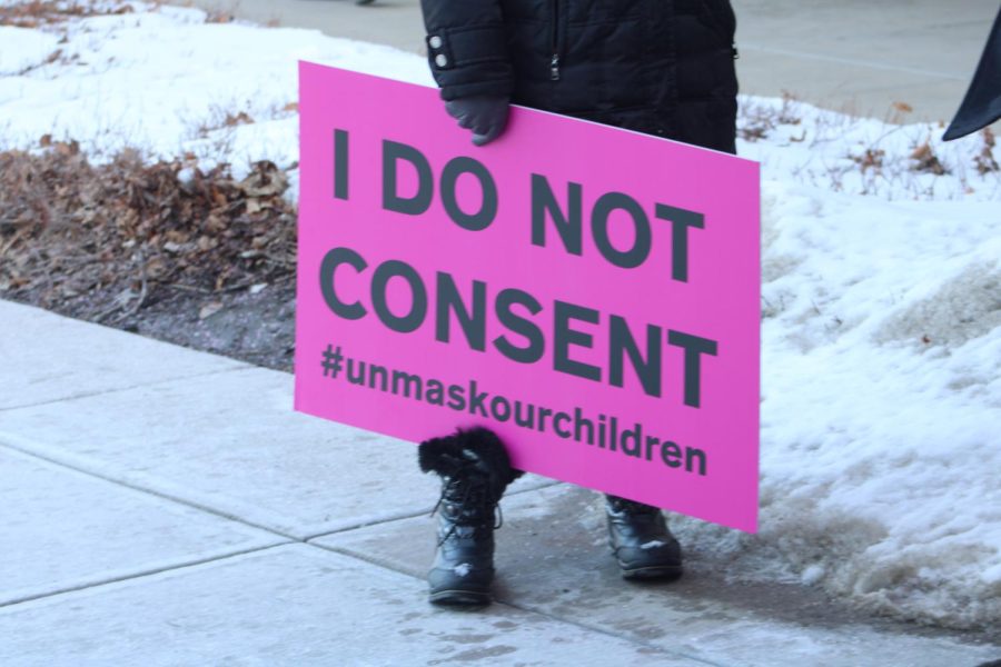 Sign shown says I Do Not Consent #unmaskourchildren
