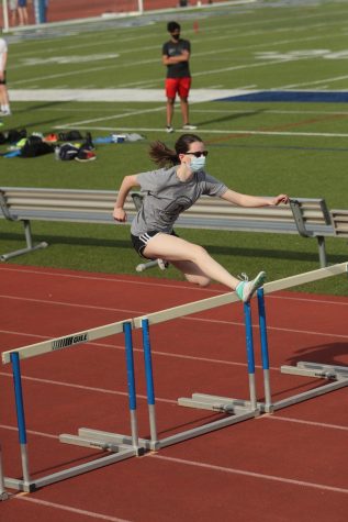 Danielle Hewitt jumping over a hurdle during her track season.
