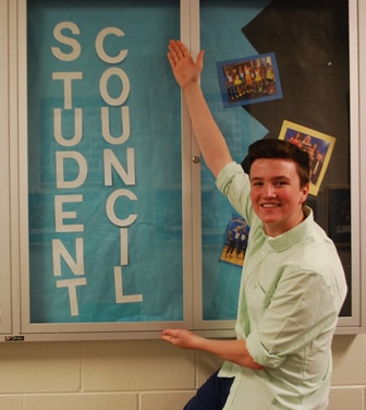 Morgan McDonough (11) poses by Student Council showcase 