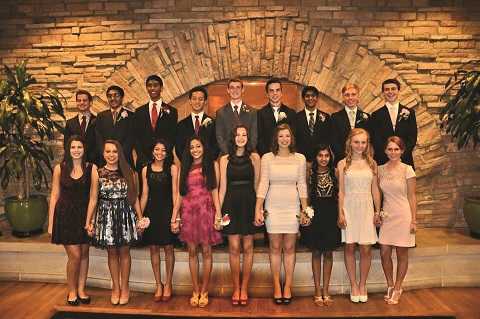 A group of juniors poses with their homecoming group in neutral, black, and red color schemes before the dance.