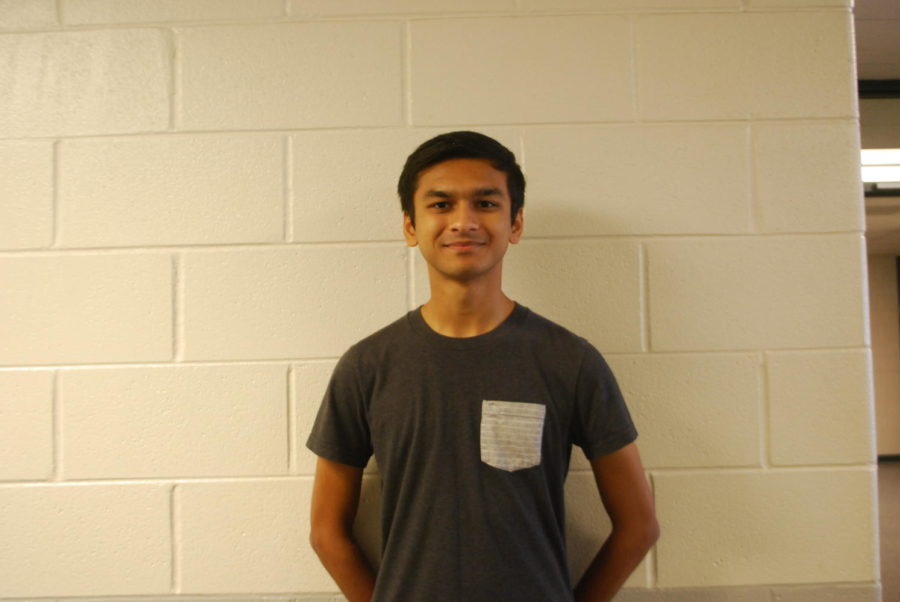 Anmol Parande, a VHHS senior, poses in front of a white brick wall.