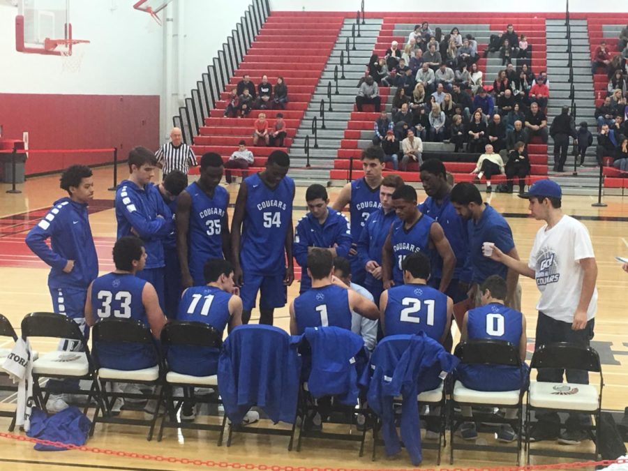 The boys baskeball team huddles around Coach McCarty during a timeout in their game at Deerfield on Dec. 2. The Cougars lost to the Warriors 65-30.