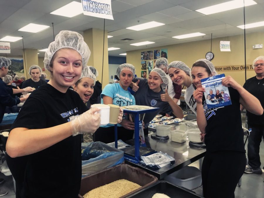 Some sophomores pause from their community service work at Feed My Starving Children to pose for a photo.