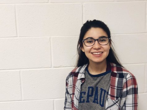 Maddie Fernandez smiles in front of a white wall in a DePaul shirt.