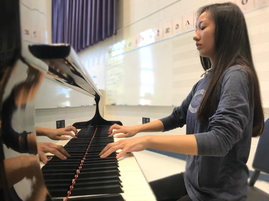 This photo depicts a student playing the piano.