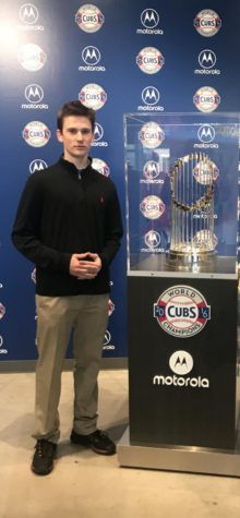 TSP writer Samuel Polisky stands in front of the Cubs baseball trophy.