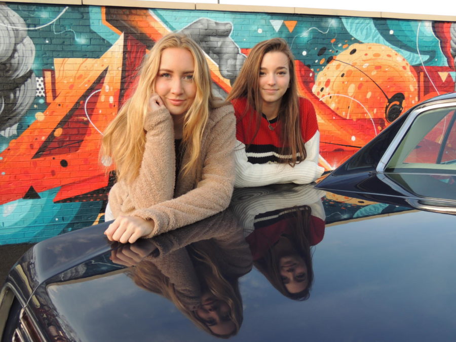 Olivia Sheldon (12) and Lexi Smolic (12) pose in front of an antique car.