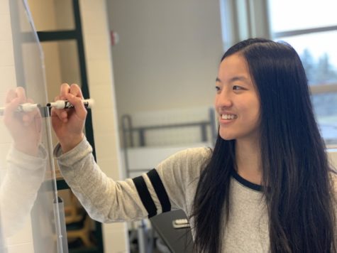 This is a photo of Rachel Liu writing on a white board.
