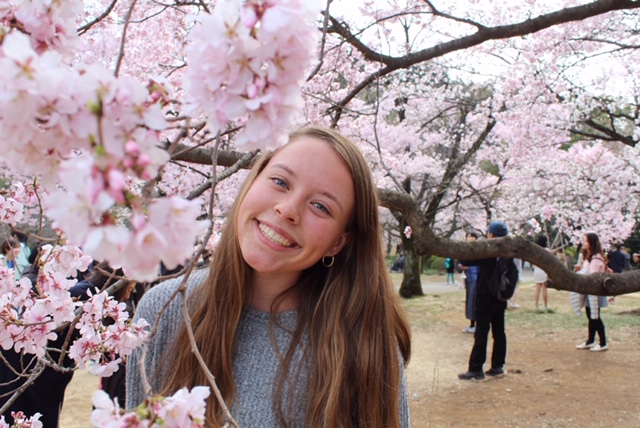Picture of Marley Reback in Japan with a cherry blossom tree.