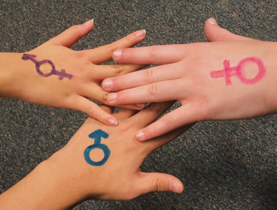 Three hands come together to show unity.