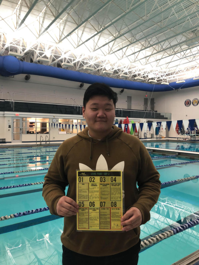 David Jun is standing in front of the pool holding a schedule for one of his cougar guard lessons.