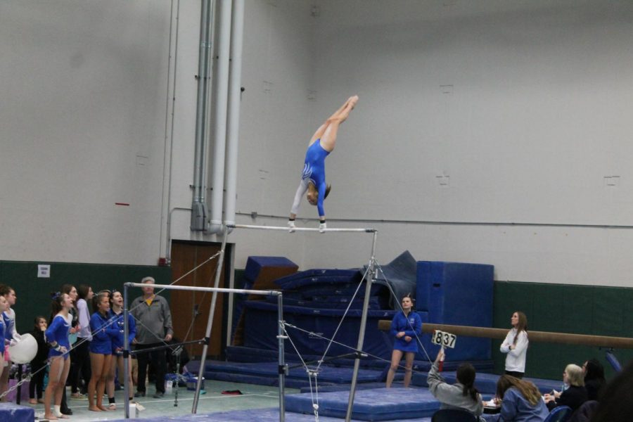 Dylan Sides (11) competes in the regional meet on the uneven bars.