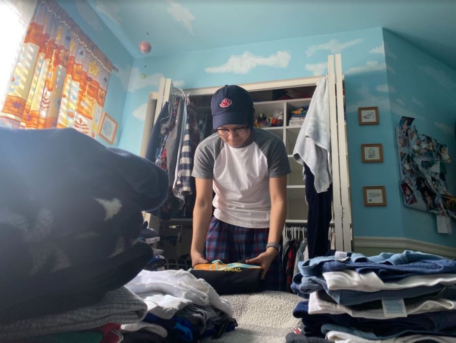 Brandon Carido (12) sifts through old clothes to clean out his closet. He even stumbles across shirts of his from preschool!