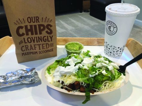 Luke's Chipotle bowl is pictured with a side of chips and a drink.