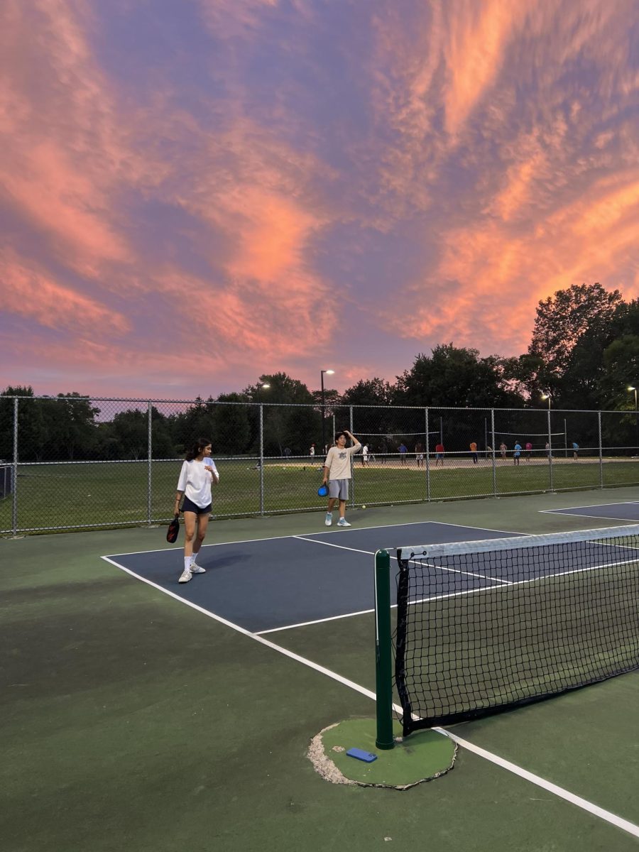 This is a photo of Nandini Kandamuri and Byungyoon You standing on a pickleball court during sunset.