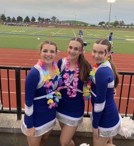 Students in cheer posing for a picture during a home football game