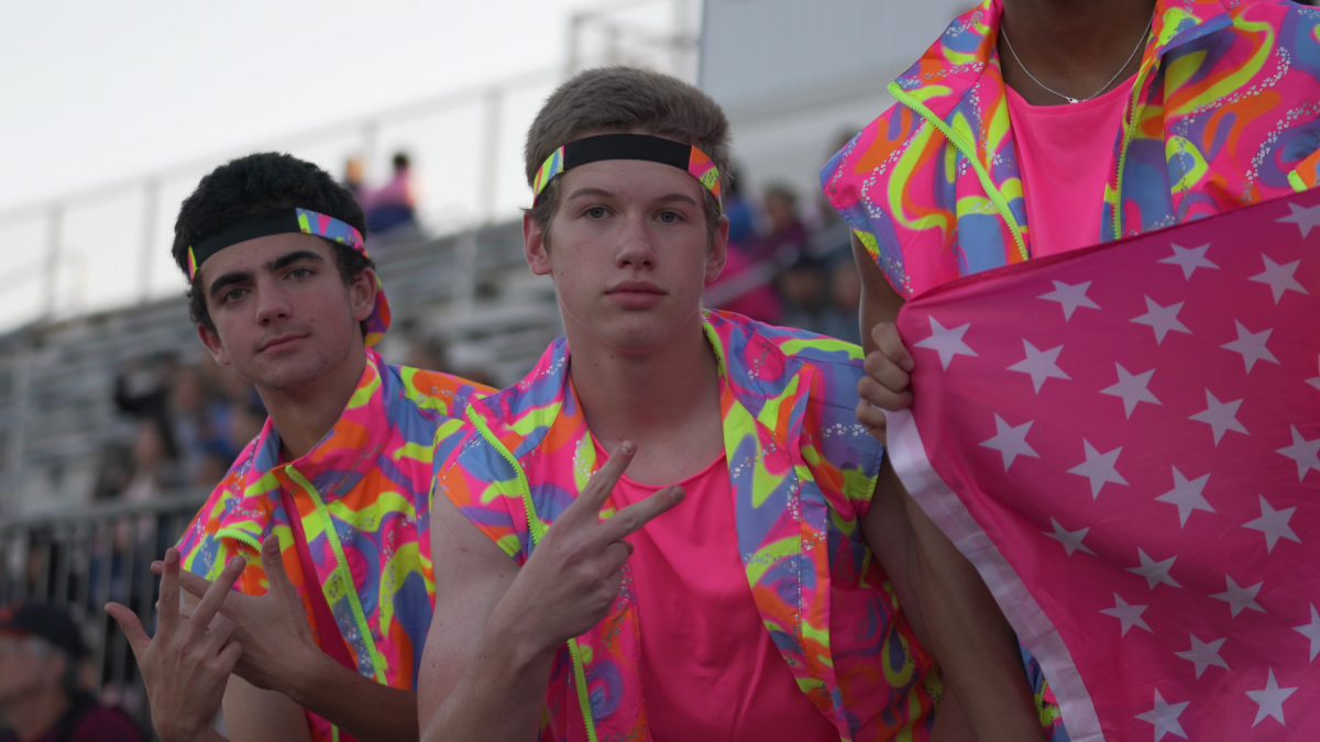 Luke Angelos (12) and Riley Mitchell (12), dressed as Ken from the Barbie movie, cheer for VHHS in the student section on Oct. 4 varsity football game against Niles West.