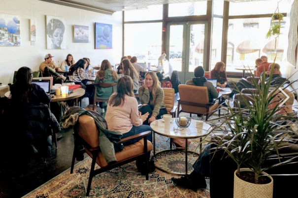 People seated in a cafe, working and eating.