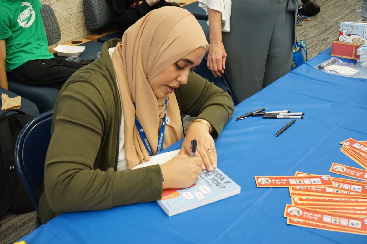 Huda Fahmy signs books for students at VHHS.