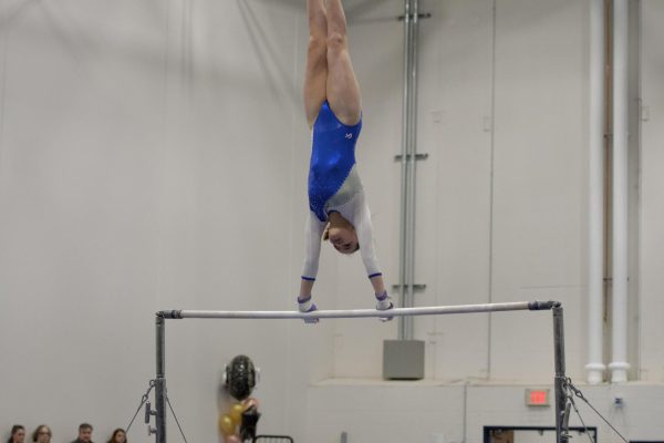 During gymnastics Livy Tran does a cast handstand on the high bar.