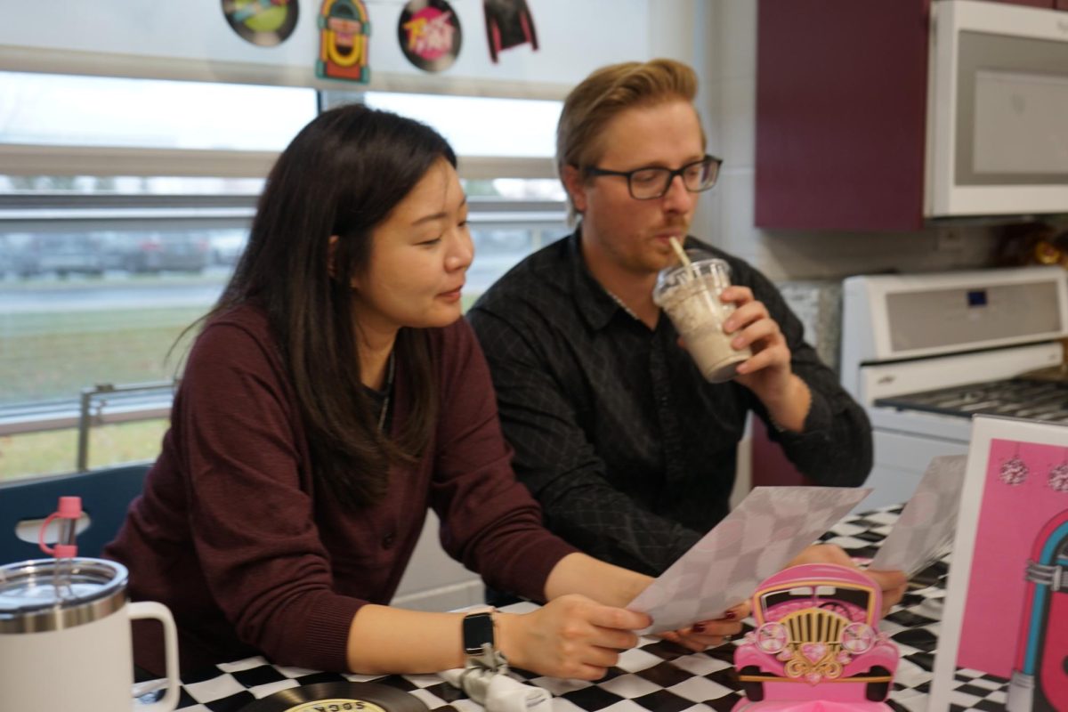 Yon Choi and Neal Hausmann read the menus while waiting for their meals.