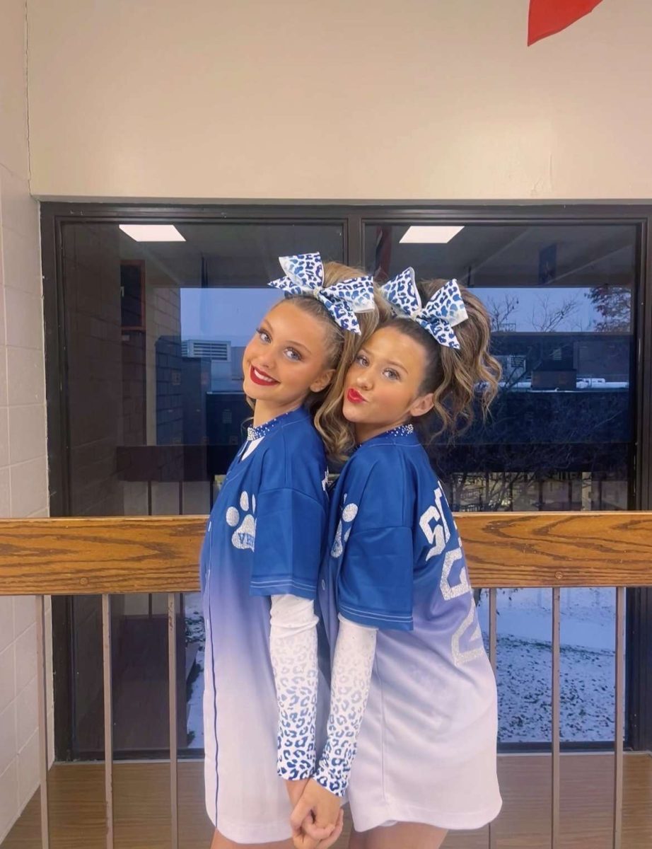 Caity Dodson (12) and Tatum Surber (12) pose in their uniforms and jerseys as seniors.