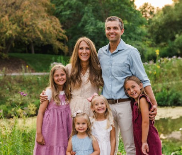 Andrew and Tara Young take a family photo with their four daughters. 