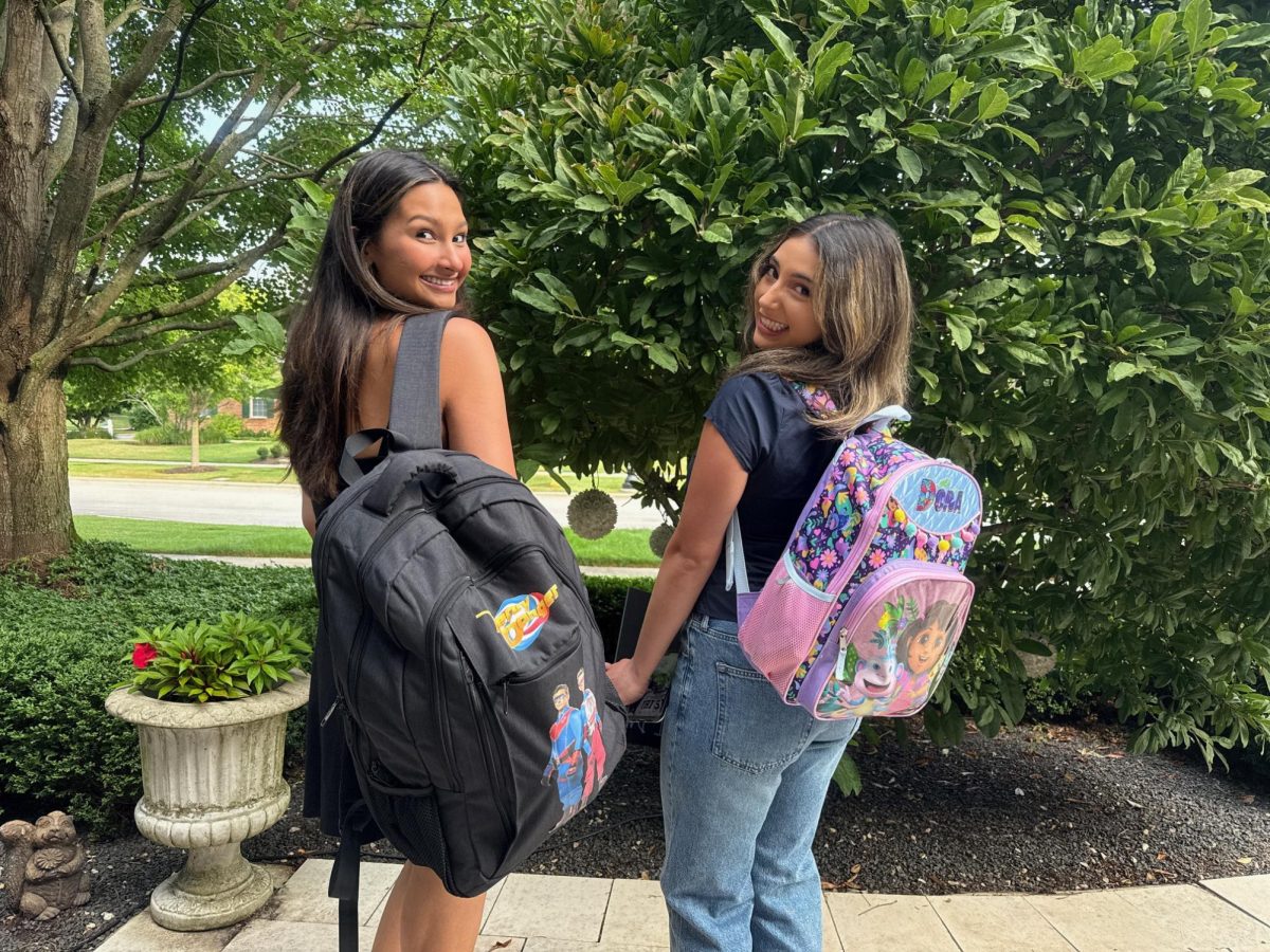 Maya Wadhwani [left] (12) and Ashley Rojas [right] (12) Posing with their senior backpacks before the first day of school.