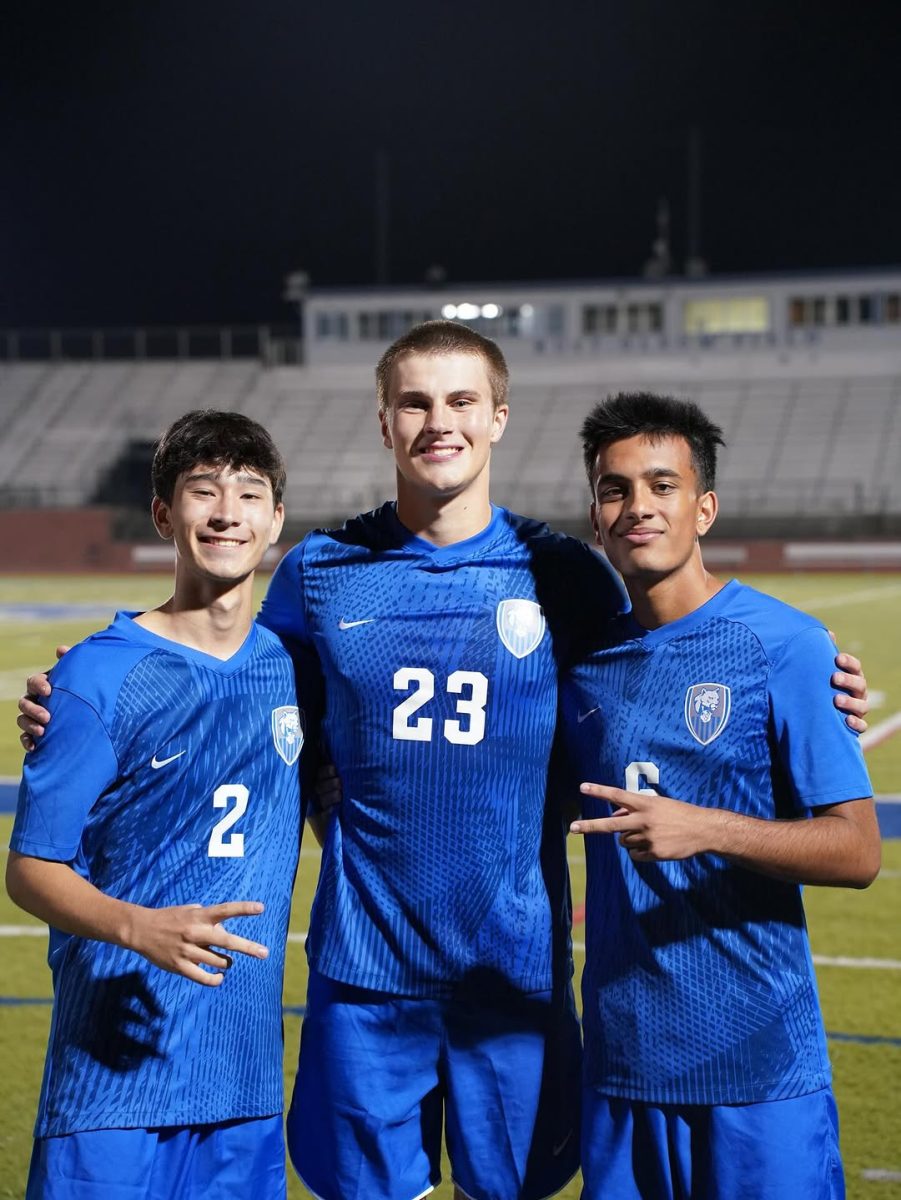 Devan Acharya poses with fellow teammates Nathan Perritt [left] (12) and Tyler Ling [middle] on the Sepember 11th game.